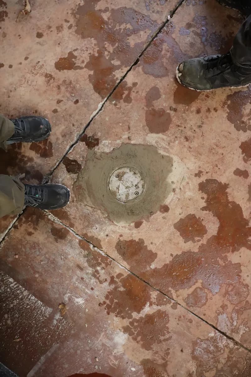A monitoring well cover grouted flush into a floor