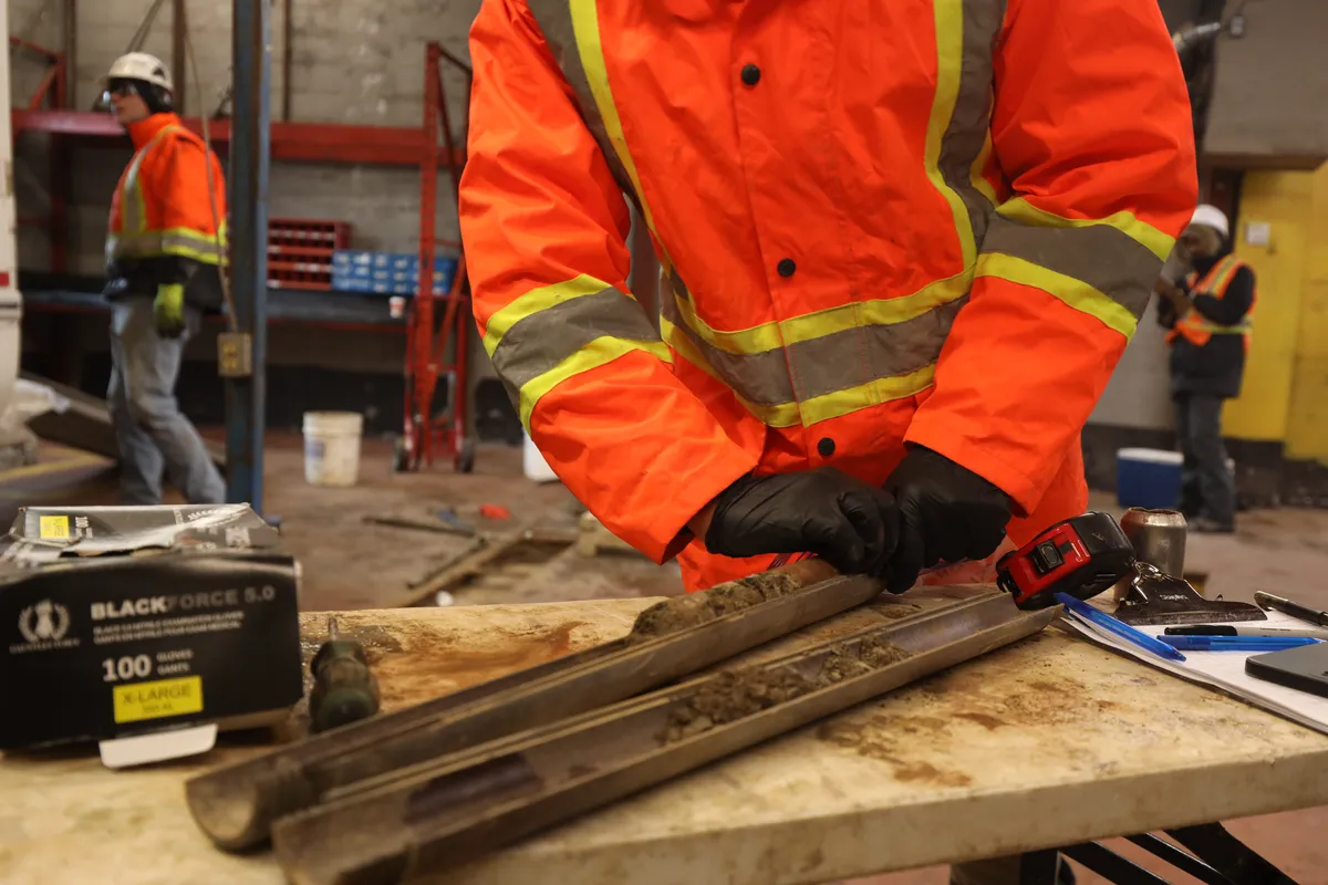Hands working recovered material along a split tube
