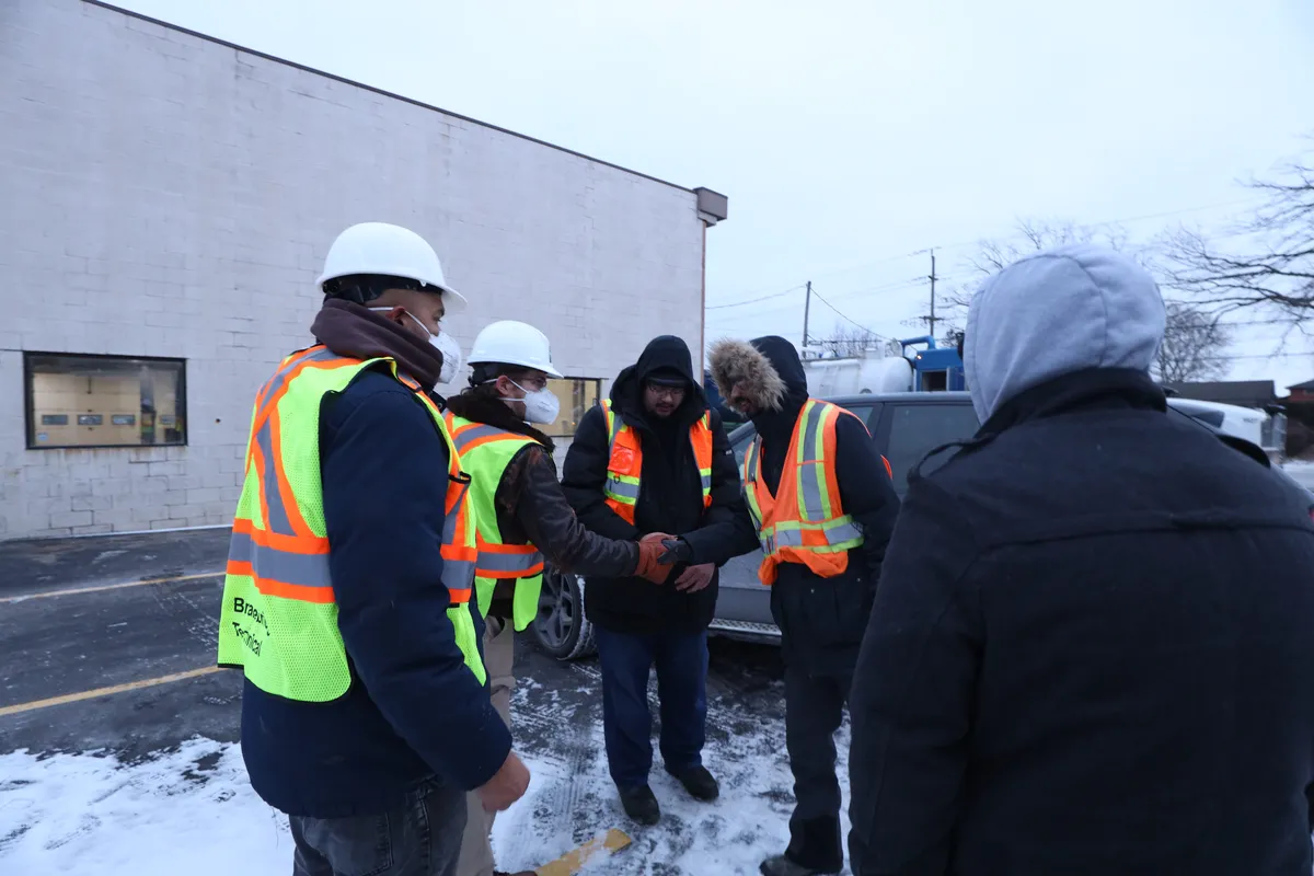 Crew in the yard in snow before the work starts